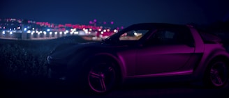 A sleek luxury car illuminated by subtle magenta and blue neon glows in an urban night setting.