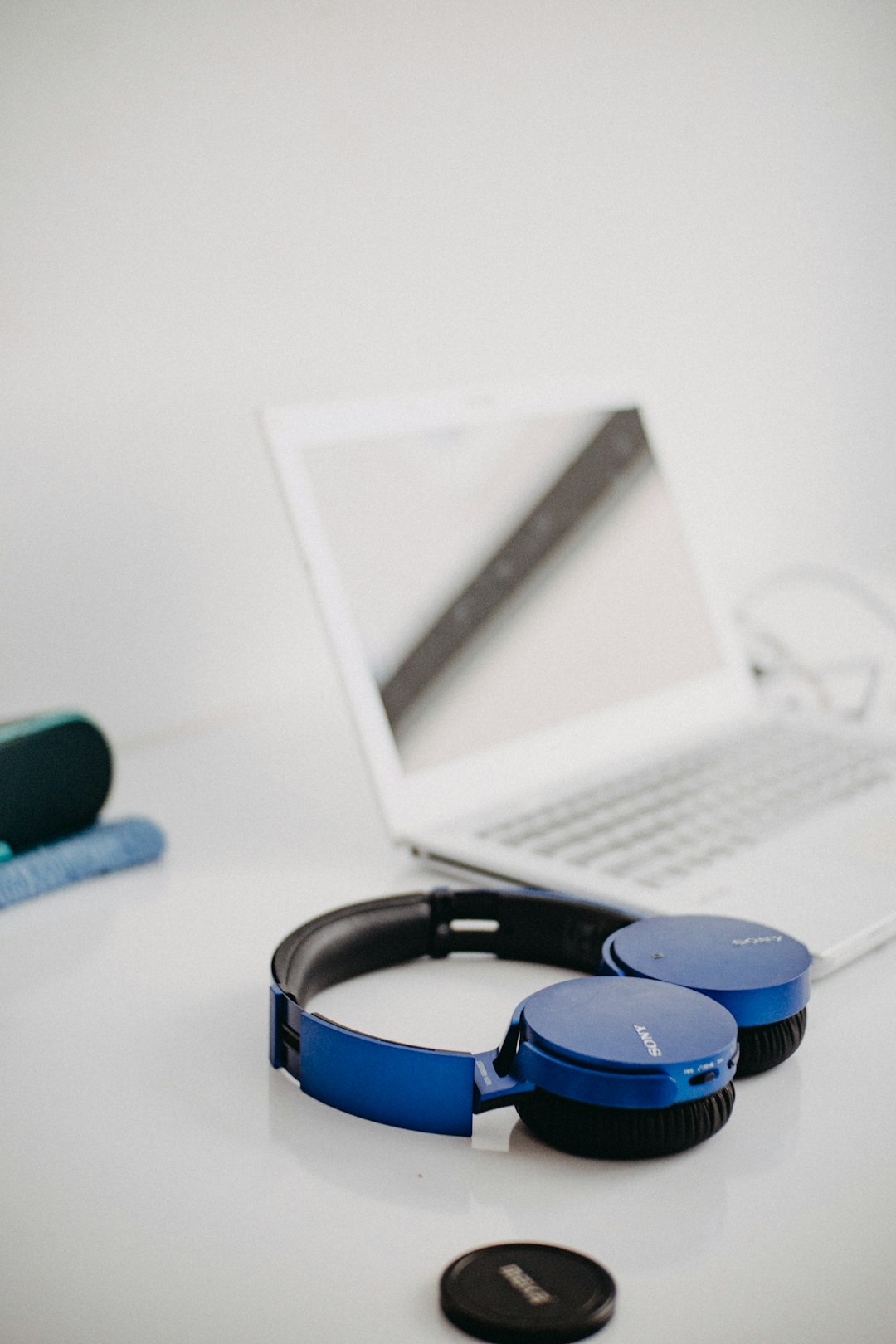 black and blue headphones beside white tablet computer