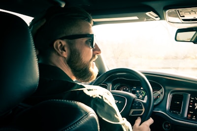 man in black jacket driving car