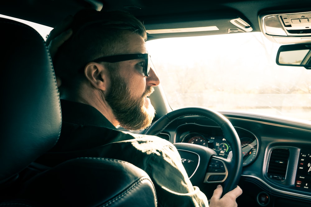 man in black jacket driving car