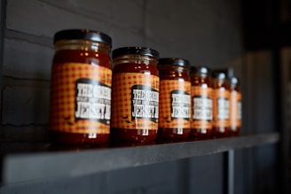 brown glass jars on black wooden shelf