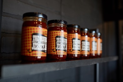 brown glass jars on black wooden shelf