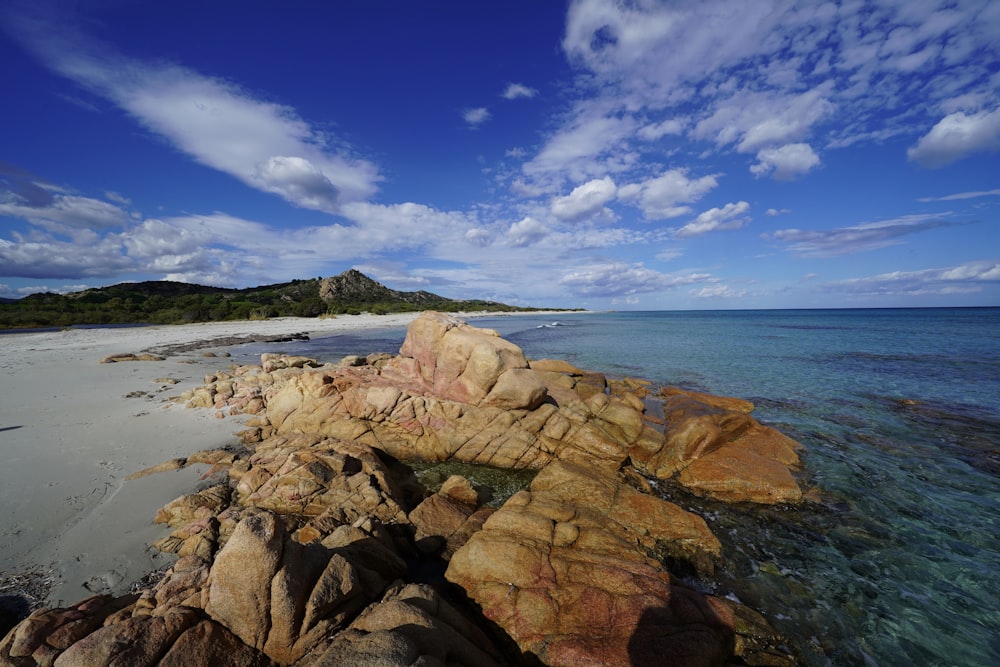 brown rock formation near body of water during daytime