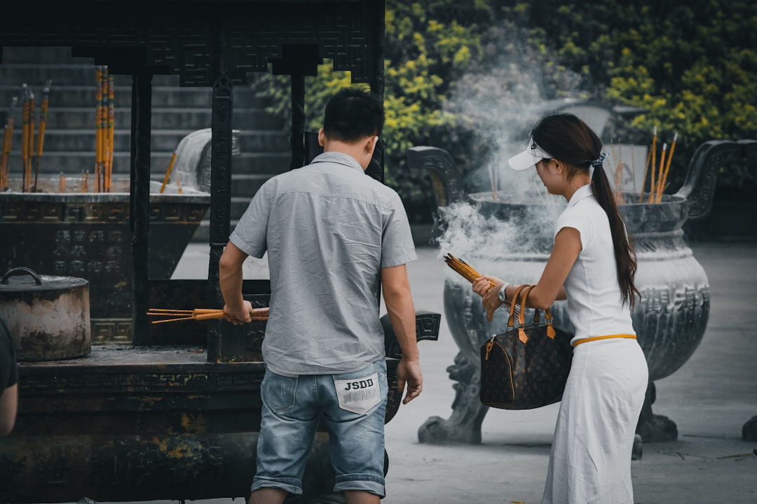 man in gray crew neck t-shirt and blue denim jeans holding brown stick