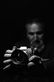 grayscale photo of man holding camera