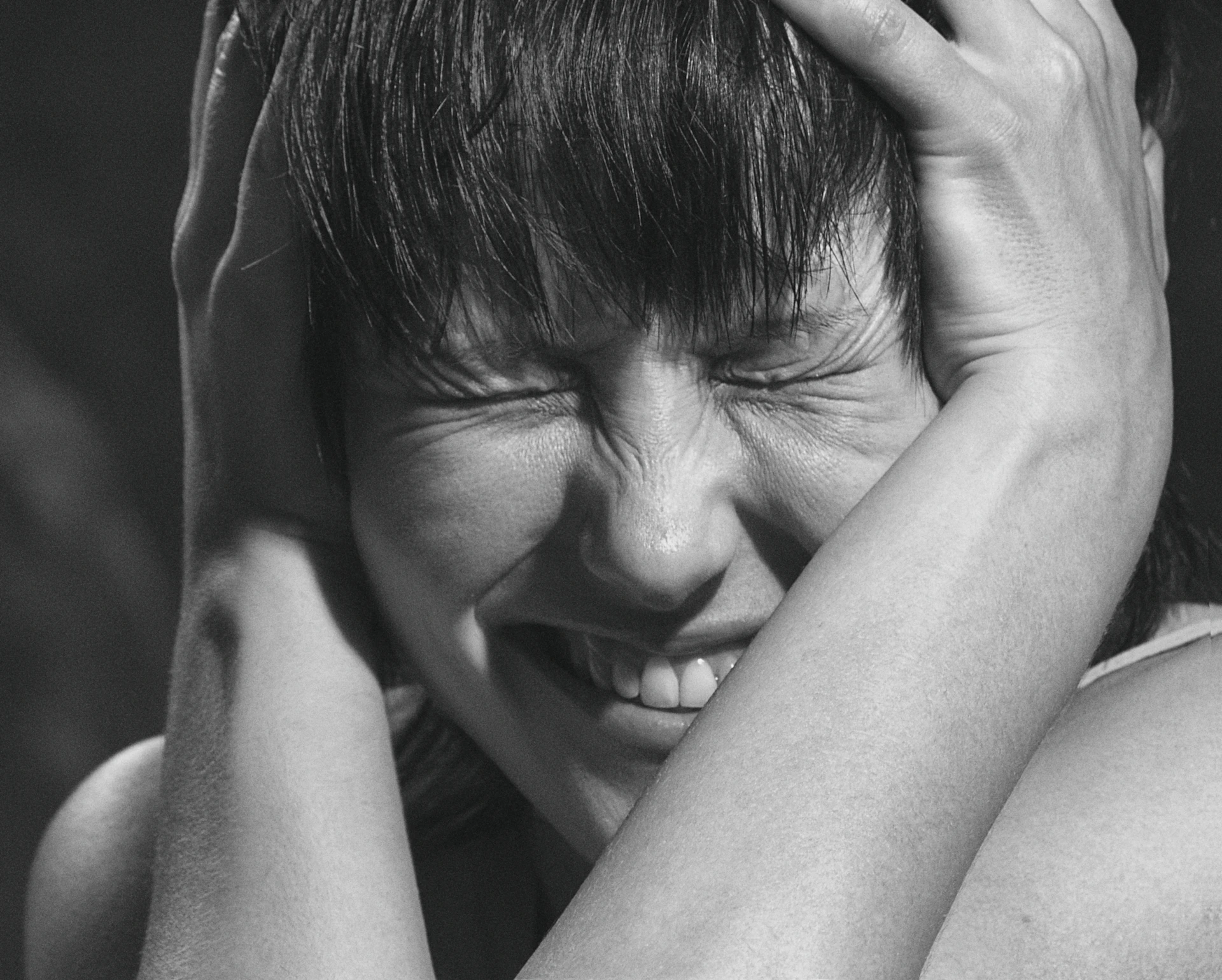 grayscale photo of woman covering her face with her hands