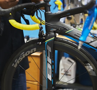 man in black jacket holding black bicycle wheel