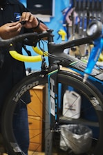 man in black jacket holding black bicycle wheel