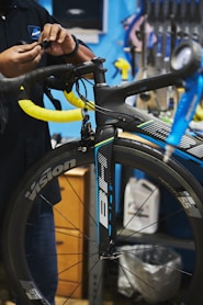 man in black jacket holding black bicycle wheel