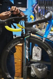 man in black jacket holding black bicycle wheel