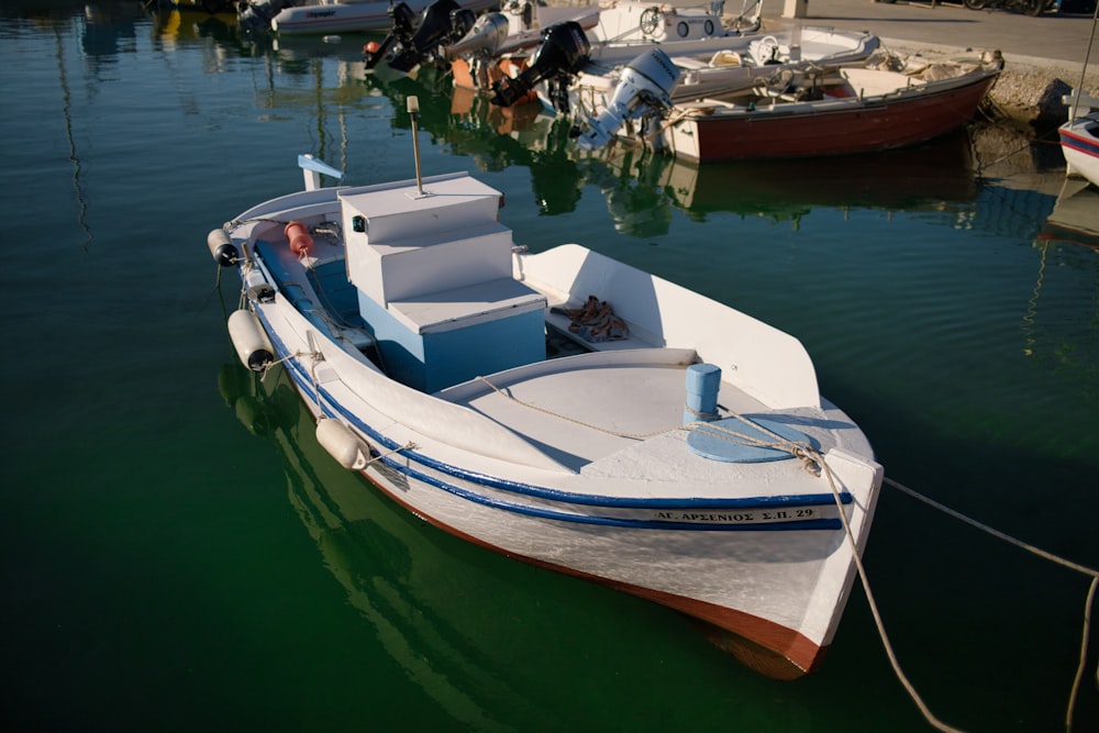 white and blue boat on water during daytime