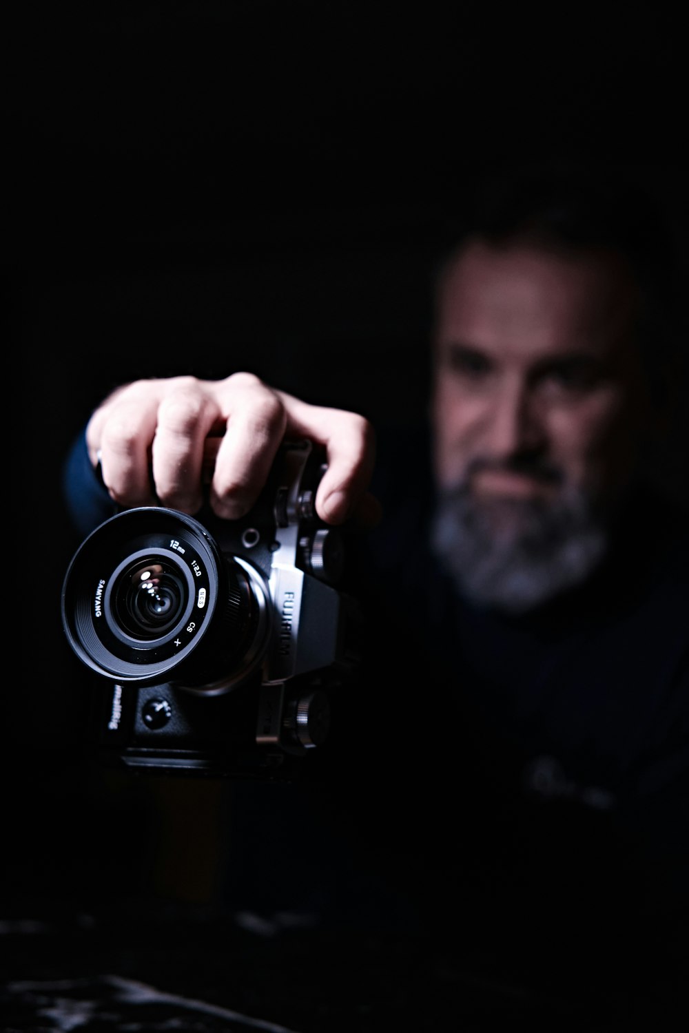 man in blue shirt holding black camera