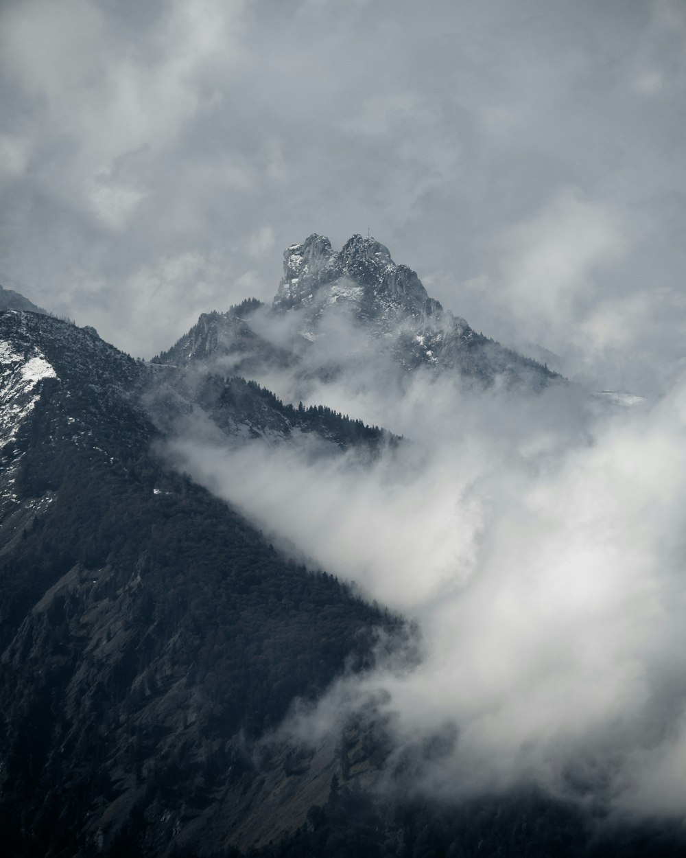 black and white mountain under white clouds