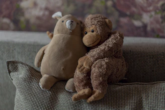 A charming collection of jungle animal plushies including a lion, elephant, and monkey arranged on a soft cushion.