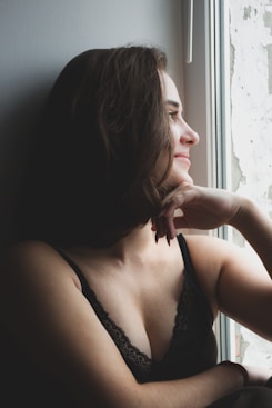 woman in black brassiere sitting on black sofa