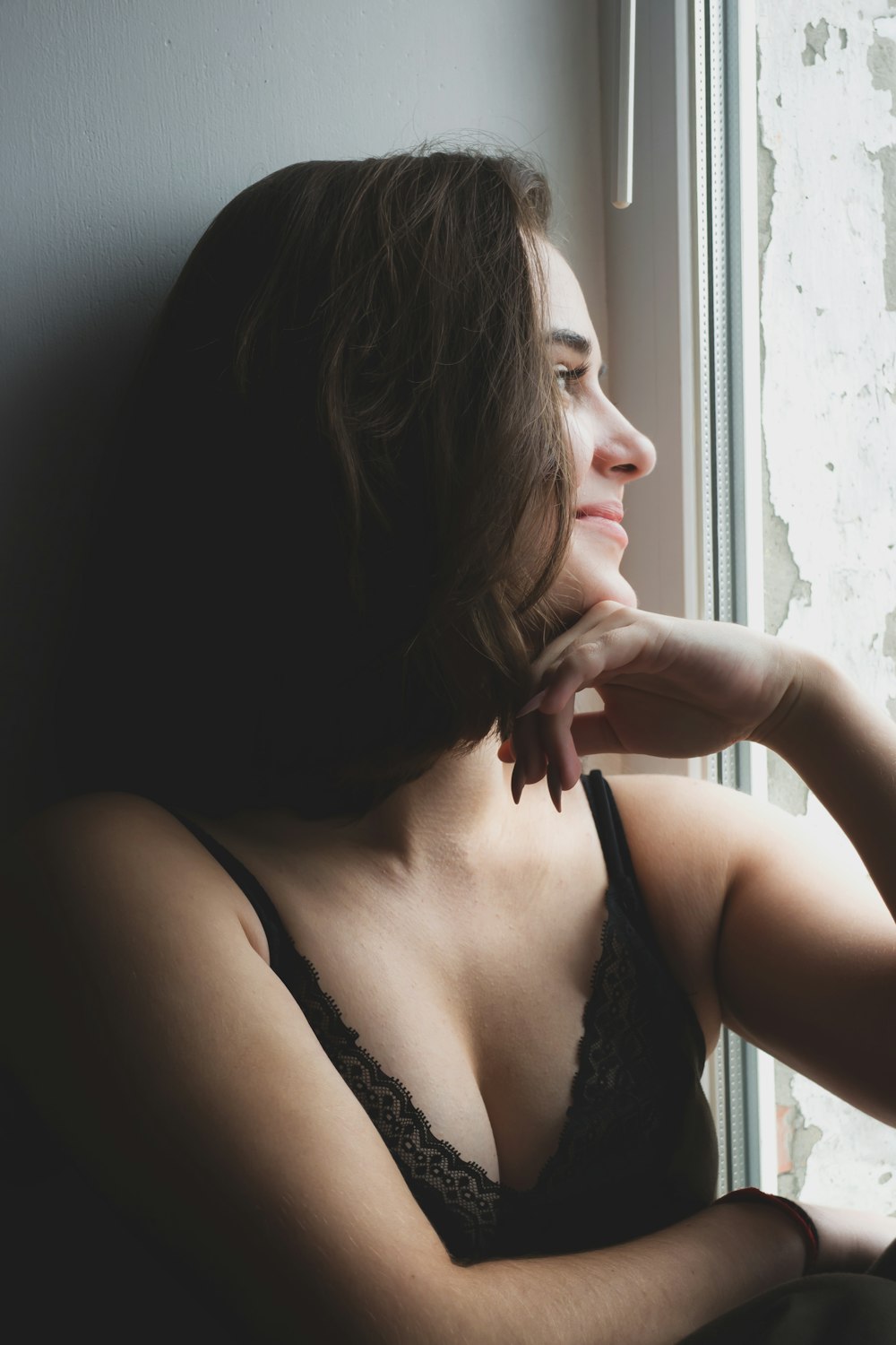 woman in black brassiere sitting on black sofa