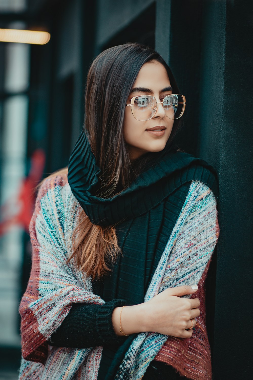 Femme en écharpe bleue et blanche portant des lunettes à monture noire