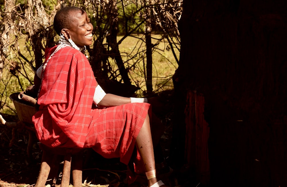 woman in red and white checkered dress sitting on brown wooden chair