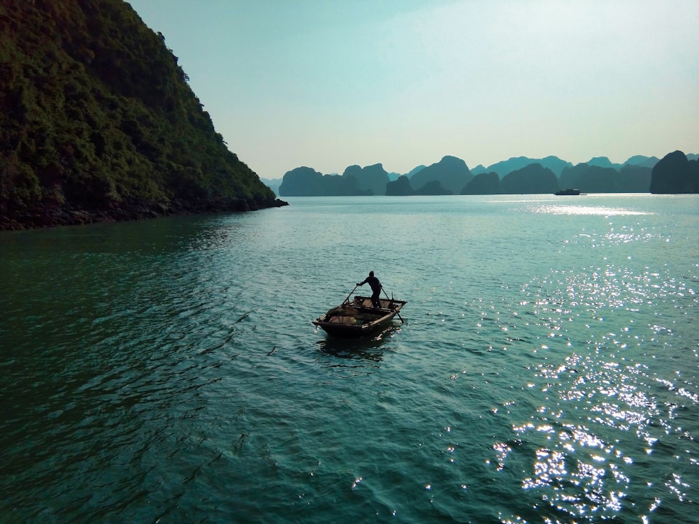 person riding on boat on body of water during daytime