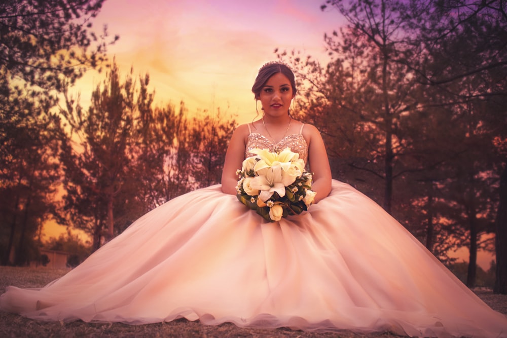 woman in white floral dress standing near trees during daytime