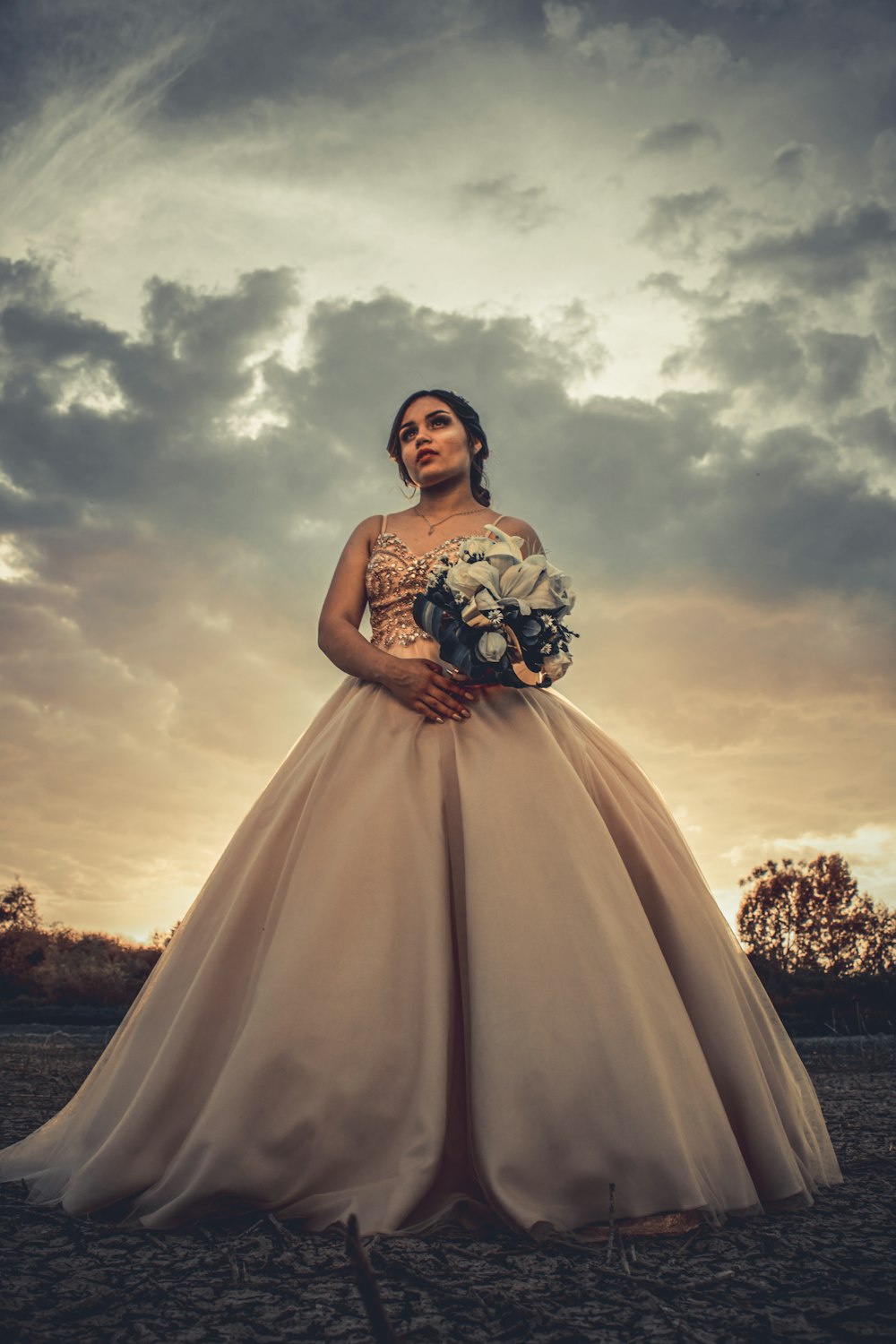 woman in white floral dress standing on field during sunset