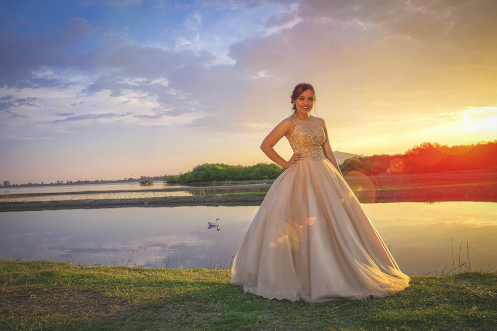 woman in white dress standing on green grass field during daytime