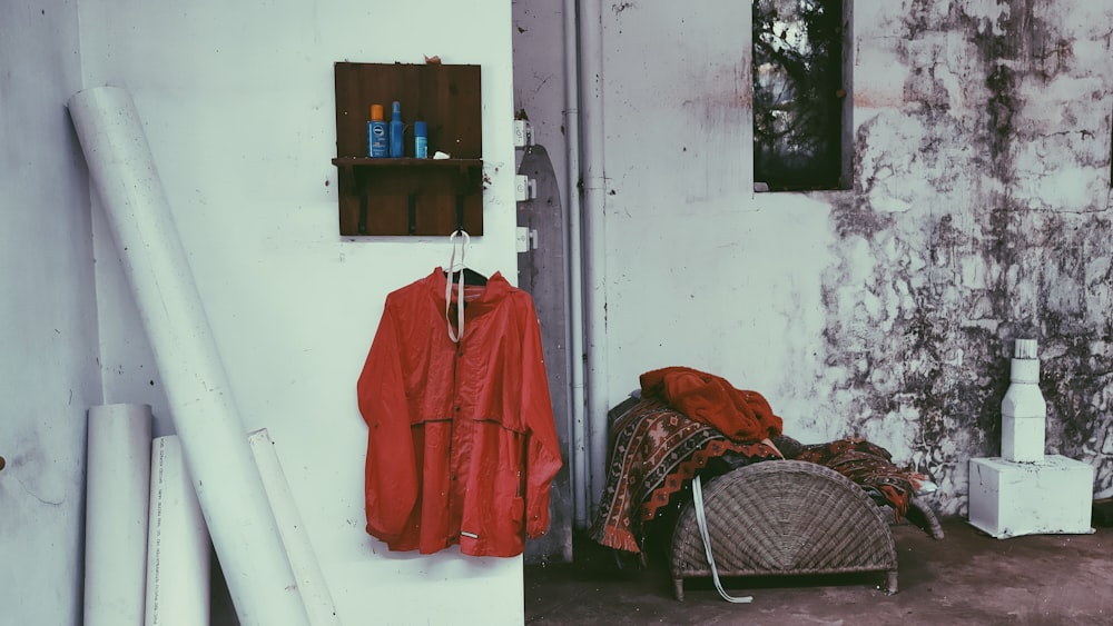 red long sleeve shirt hanged on white plastic clothes hanger