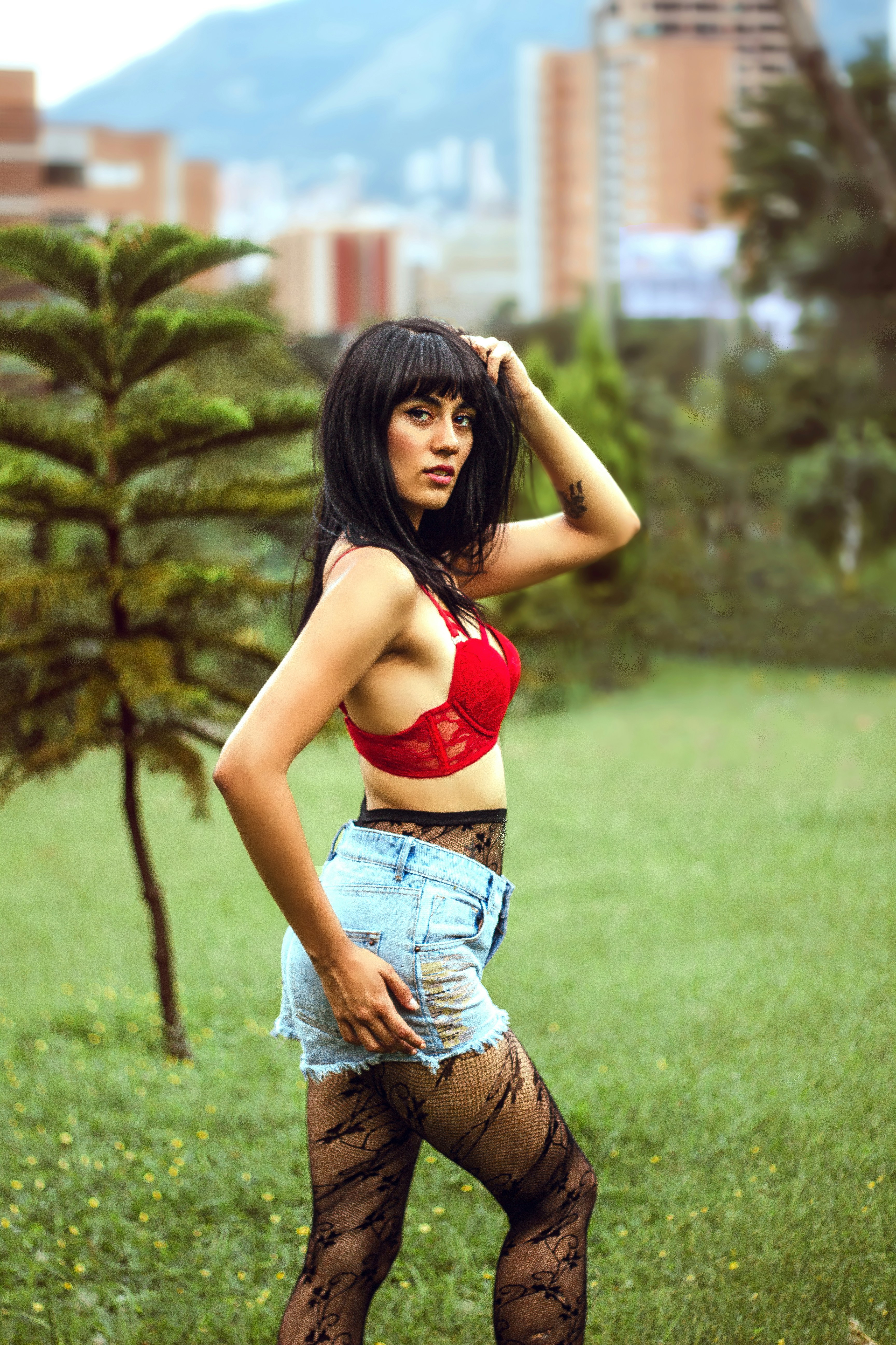 Wanita dengan bra olahraga merah dan jeans denim biru