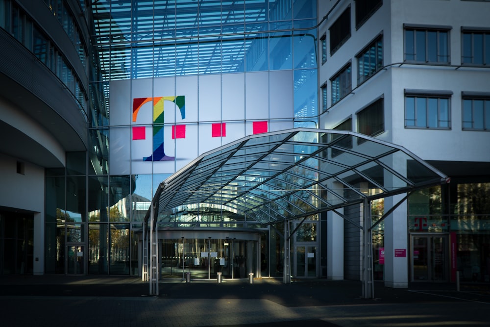 white red and yellow flags on pole in front of glass building