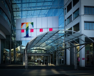 white red and yellow flags on pole in front of glass building