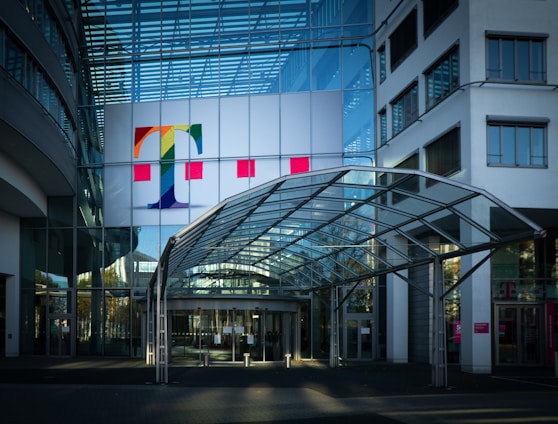 white red and yellow flags on pole in front of glass building