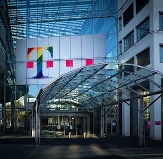 white red and yellow flags on pole in front of glass building