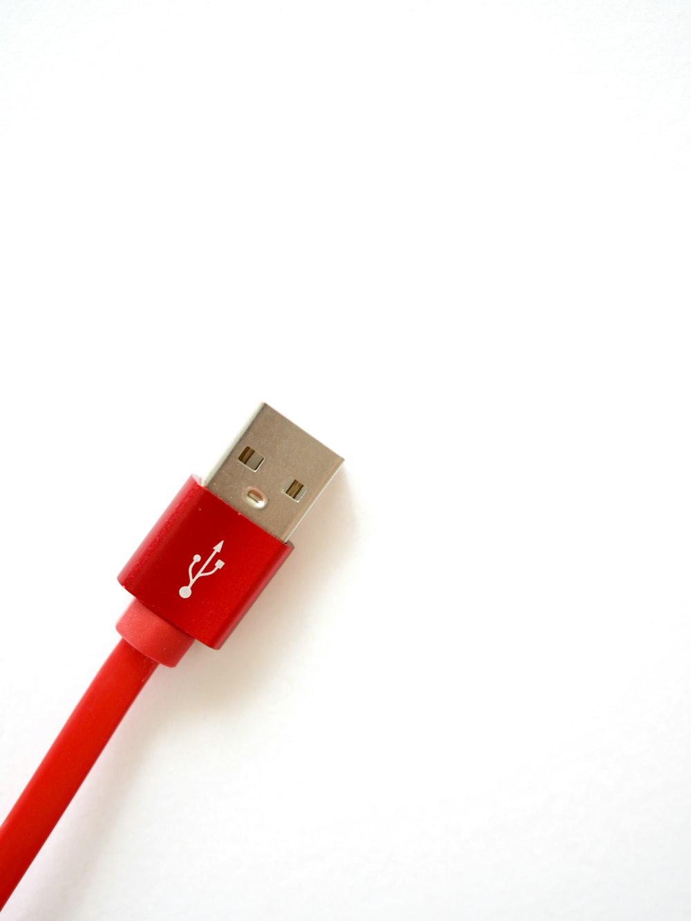 Cable USB rojo sobre superficie blanca