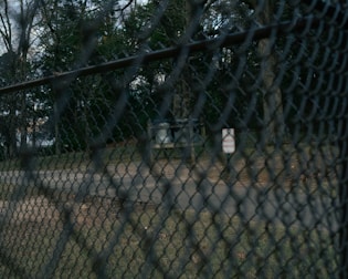 Installation of privacy tape on a chain-link fence in an outdoor park.