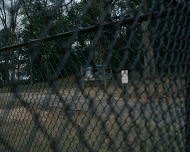 Installation of privacy tape on a chain-link fence in an outdoor park.