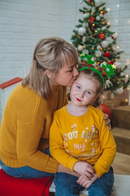 A mother and daughter laughing together, both wearing cozy matching sweaters from lookorye.