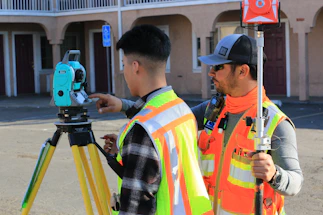 man in orange white and black striped long sleeve shirt holding black dslr camera