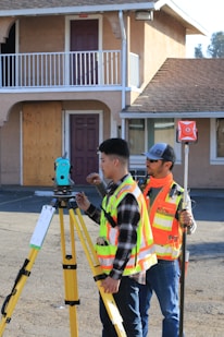 man in yellow and black plaid shirt holding green and black camera