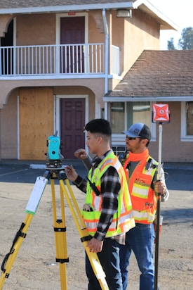 man in yellow and black plaid shirt holding green and black camera