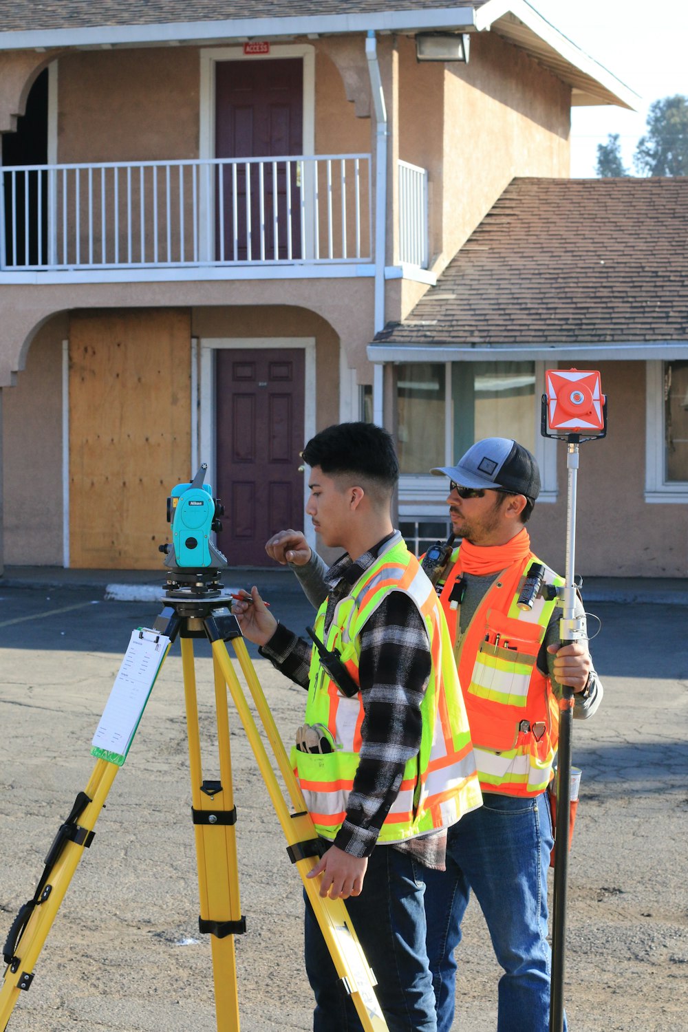 man in yellow and black plaid shirt holding green and black camera