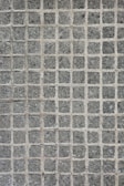 A texture consisting of evenly spaced stone tiles arranged in a grid pattern. Each tile has a rough, textured surface with slight variations in color and tone.