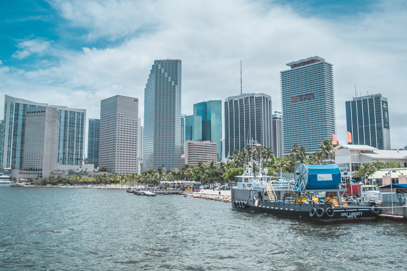 Boat on the water beside city buildings during the day