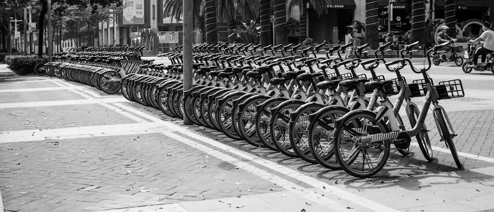 grayscale photo of bicycle parked on sidewalk