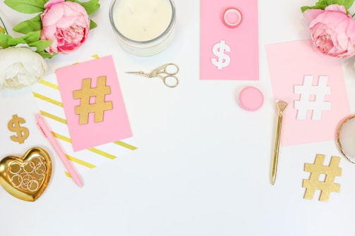 Elegant flat lay of photo prints with beige and pink accents on a table.