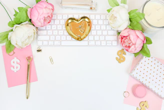 A cozy workspace with soft blush pink accents, showcasing personalized photo frames and gift boxes.