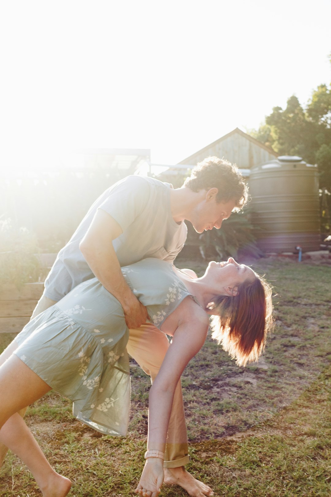 man in green t-shirt kissing woman in white dress