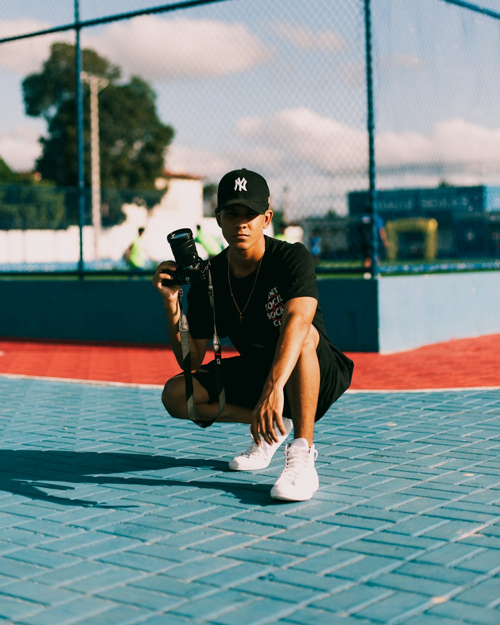 man in black t-shirt and white shorts holding black dslr camera