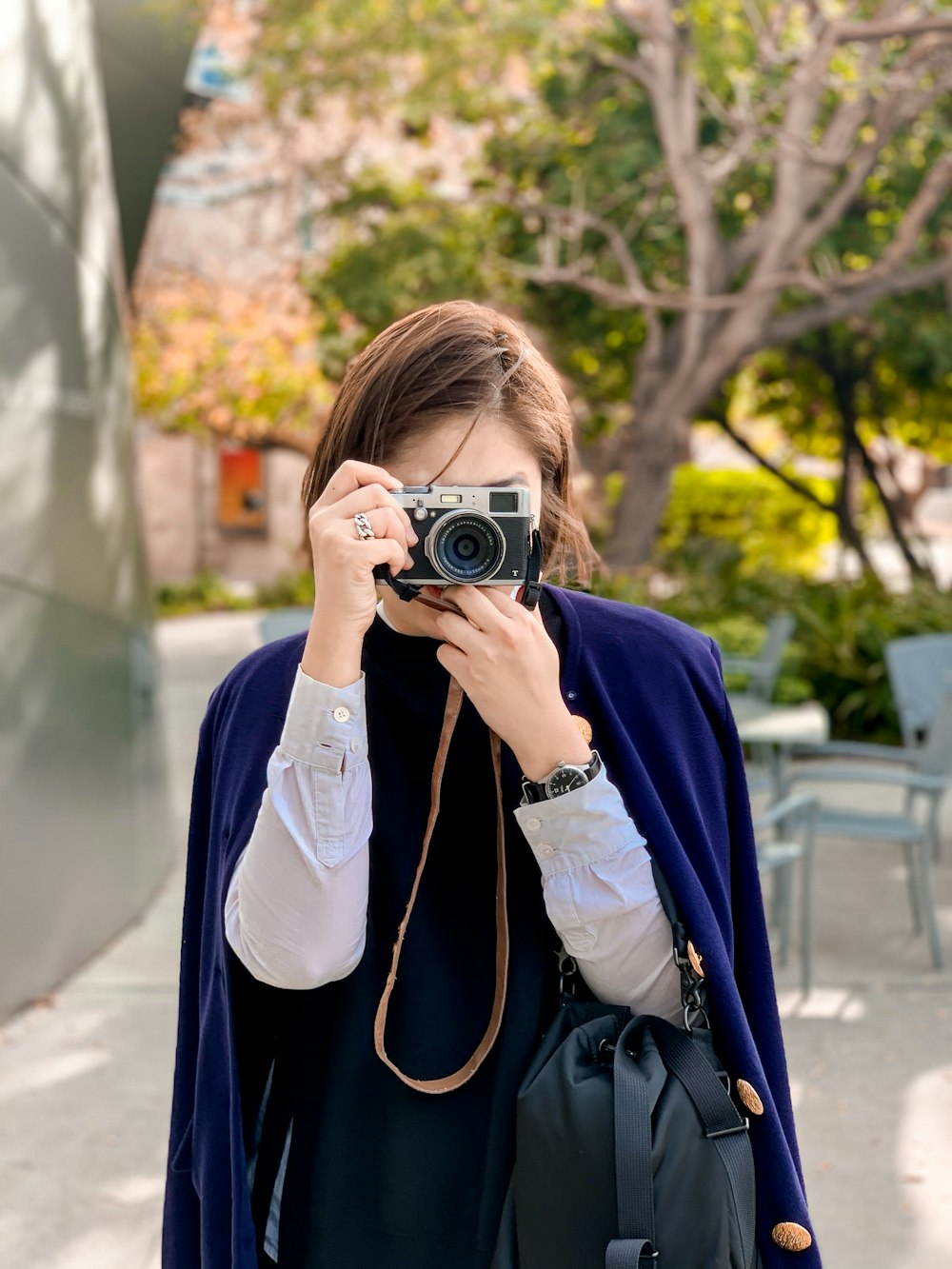 woman in blue jacket holding camera