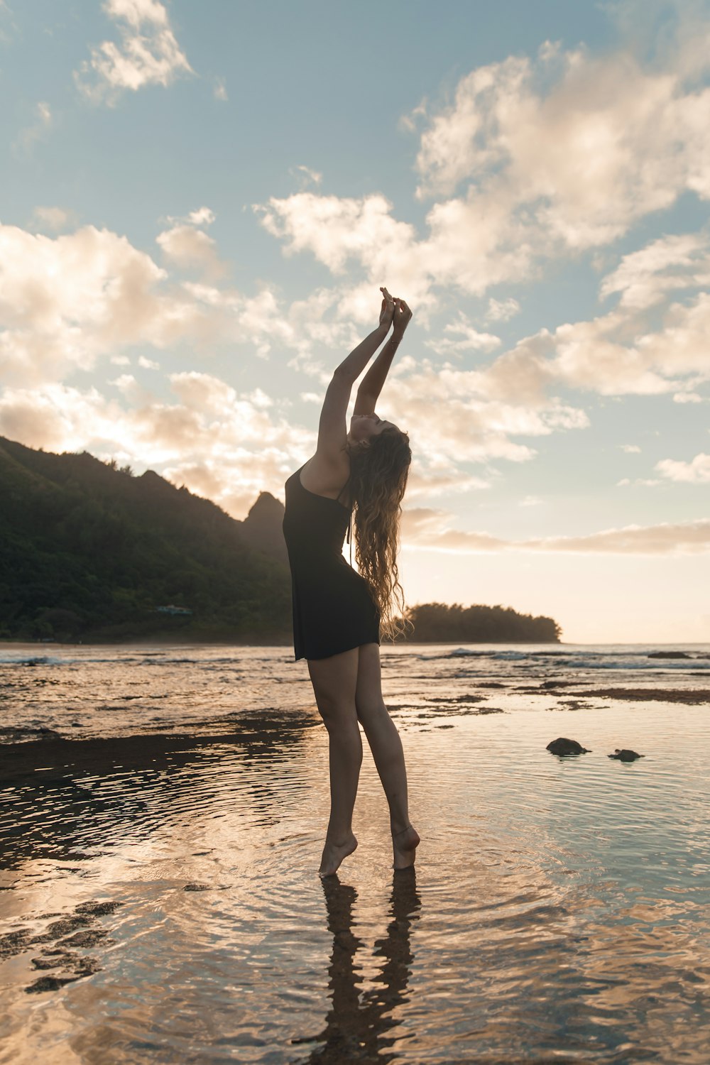 woman in black tank top standing on seashore during daytime