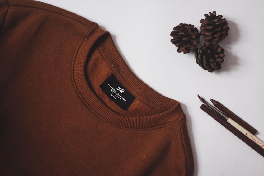 brown crew neck shirt on white table